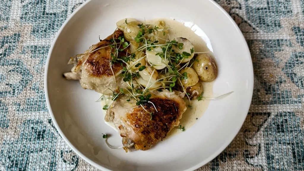 Photograph of Chicken thighs with creamy leek and caper sauce.