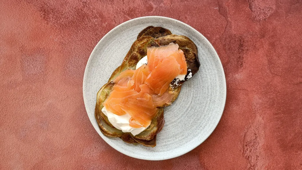 Photograph of Crispy rosemary and garlic potato galettes with smoked salmon.