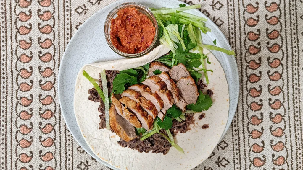 Photograph of Duck & black bean tostadas.